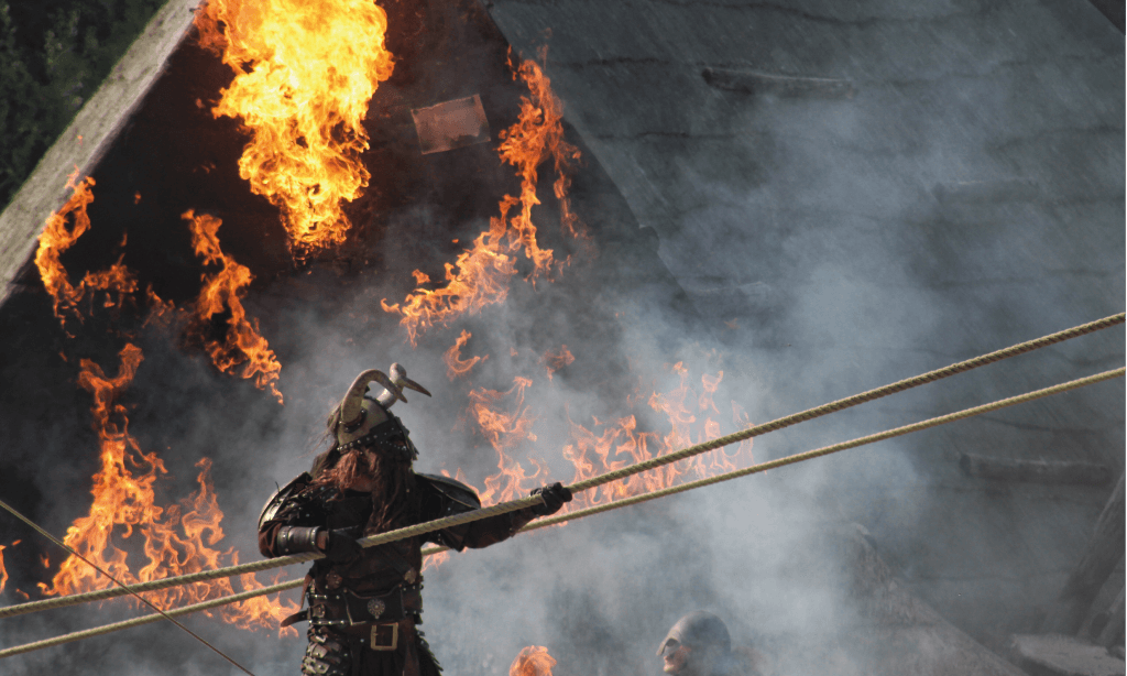 Photo d'un viking avec un bateau en feu en arrière plan